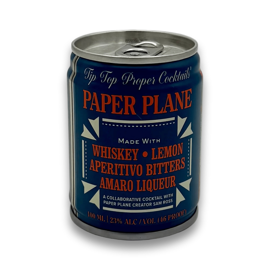 Can of Paper Plane cocktail. The appearance of the can is dark indigo with red text &